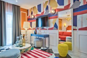 a living room with a couch and a tv at HOLM Boutique & SPA - IK Collection in St. Julianʼs