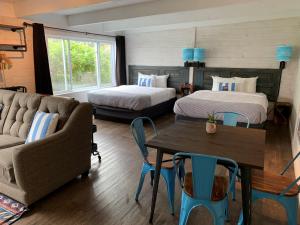 a room with two beds and a couch and a table at Beachfront Inn in Baileys Harbor