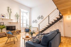 a living room with a couch and a staircase at BNBHolder Fresh Group Duplex SOL in Madrid