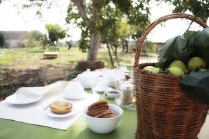 een picknicktafel met een mand met eten en snacks bij Casina Solatia in Nardò