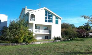 a white house with a lawn in front of it at Guesthouse Vionica in Međugorje