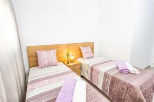 two beds in a room with purple sheets and pillows at Calpe Beach in Calpe