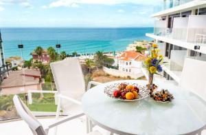a table with a bowl of fruit on a balcony with the ocean at Calpe Beach in Calpe
