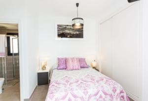 a white bedroom with a bed and a bathroom at Calpe Beach in Calpe