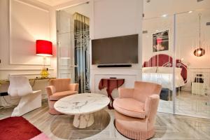 a living room with chairs and a table and a bed at HOLM Boutique & SPA - IK Collection in St. Julianʼs