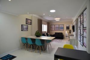 a kitchen and living room with a table and chairs at FRENTE MAR PÉ NA AREIA, na Av Atlântica in Balneário Camboriú