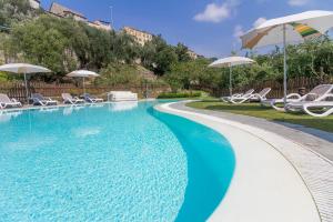 a swimming pool with chairs and umbrellas at Appartamenti Antico Frantoio Doria in Imperia