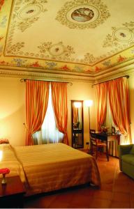 a bedroom with a large bed with orange curtains at Hotel San Claudio in Corridonia