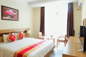a bedroom with a bed and a desk and a window at Anh Duc Hotel in Tam Ðảo