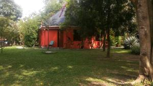 a red cabin with a chair in a park at White Castle Hotel Arua in Gulu