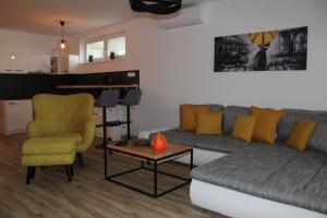 a living room with a couch and a chair and a table at Apartment ANNO in Dunajská Streda