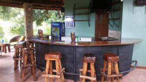 a bar with six wooden stools around it at White Castle Hotel Arua in Gulu