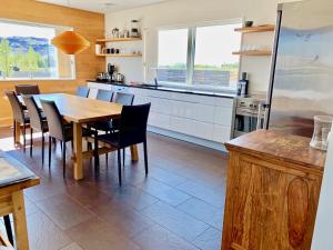 eine Küche mit einem Holztisch und Stühlen in der Unterkunft Brún in Laugaras