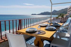 a table on a balcony with a view of the ocean at Beach House Acquamarina in Letojanni