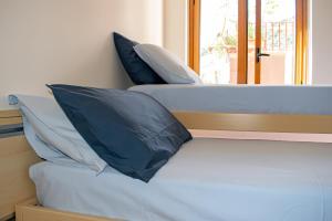 a bed with blue pillows on it in a room at Beach House Acquamarina in Letojanni