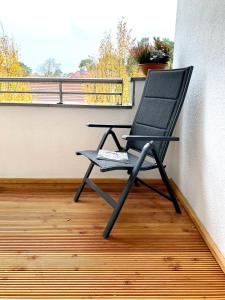 einen schwarzen Stuhl auf dem Balkon in der Unterkunft Ferienwohnung Bad Saarow in Bad Saarow