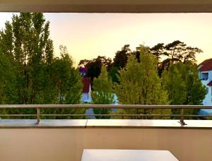 Blick auf einen Balkon mit einer Bank und Bäumen in der Unterkunft Ferienwohnung Bad Saarow in Bad Saarow