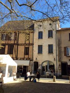 um homem sentado à mesa em frente a um edifício em Maison de Corinne em Bergerac