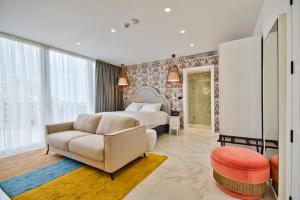 a bedroom with a bed and a couch and a chair at HOLM Boutique & SPA - IK Collection in St. Julianʼs