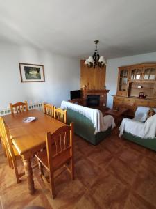 Apartamentos Rascafria Cerquilla في راسكافريا: غرفة معيشة مع طاولة وسرير وأريكة