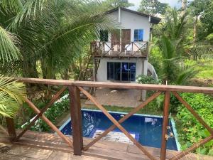 a villa with a swimming pool in front of a house at Hostal Hilltop Capurgana in Capurganá