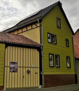 a large green and yellow building with a garage at Ferienwohnung Auf dem Hofe in Bad Langensalza
