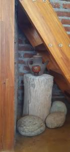 Un vaso seduto sopra un ceppo sotto una scala di Cabañas "Los Elementos", San Carlos, Salta, a San Carlos