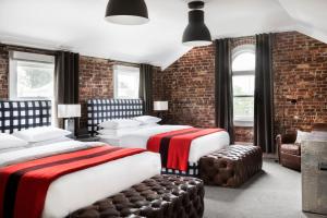 two beds in a room with brick walls and windows at The George in Montclair