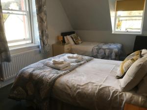 a bedroom with two beds with towels on them at Winchester House in Keswick +19 photos