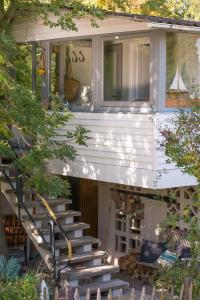 une maison blanche avec des escaliers menant à une terrasse couverte dans l'établissement Beachcottage Ingelheim, à Ingelheim-sur-le-Rhin