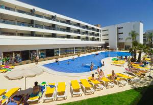 a pool with chairs and people in a hotel at Alfagar Alto da Colina in Albufeira