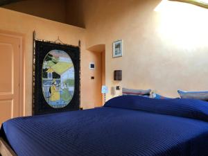 una camera con letto blu e finestra istoriata di Bed&Box a Gassino Torinese