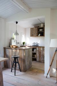 cocina con armarios de madera y taburete de madera en Beachcottage Ingelheim, en Ingelheim am Rhein