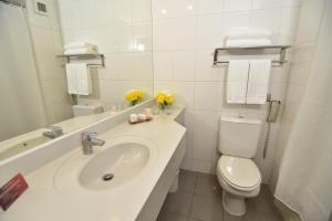 a white bathroom with a sink and a toilet at Hotel Agua del Desierto in Calama