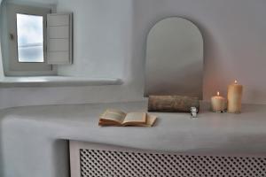 a counter with two books and two candles on it at Lava Caves in Oia