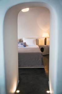 a bedroom with a bed under an archway at Lava Caves in Oia