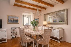 una sala da pranzo con tavolo, sedie e specchio di Apartments & Rooms Perla a Dubrovnik