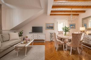 - un salon avec un canapé et une table avec des chaises dans l'établissement Apartments & Rooms Perla, à Dubrovnik