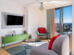 a living room with a tv and a couch and chairs at Church Street by Supercity Aparthotels in Manchester