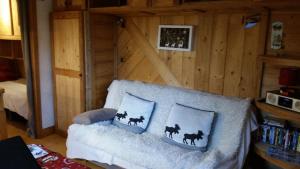 a room with a couch with two pillows on it at Joli petit appartement cosi 5 personnes maxi plein centre station les deux alpes in Les Deux Alpes