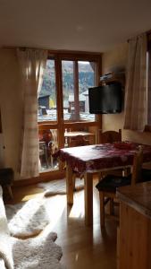a living room with a table and a large window at Joli petit appartement cosi 5 personnes maxi plein centre station les deux alpes in Les Deux Alpes