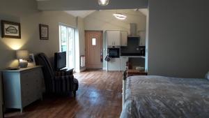 1 dormitorio con 1 cama y sala de estar con cocina en The Croft, en Sedgefield