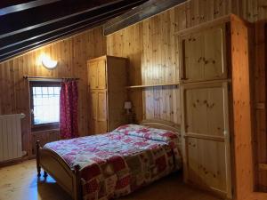 a bedroom with a bed and wooden walls at Casevacanza Val d'Ayas in Challand Saint Anselme