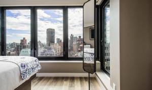 a bedroom with a view of a city at Pestana Park Avenue in New York