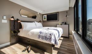 a bedroom with a bed and a tv and a window at Pestana Park Avenue in New York
