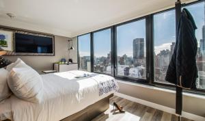 a bedroom with a bed and a large window at Pestana Park Avenue in New York