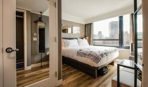 a bedroom with a bed and a large window at Pestana Park Avenue in New York