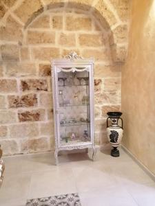 ein weißer Schrank in einem Raum mit einer Vase in der Unterkunft Borgo Salentino in San Vito dei Normanni
