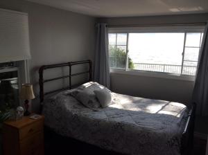 ein Schlafzimmer mit einem Bett und einem großen Fenster in der Unterkunft A Day at the Lake Cottage in Colchester