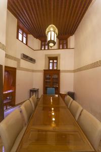 una sala de conferencias con una larga mesa de madera y una lámpara de araña en Riad Said, en Fez